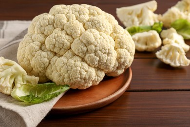 Plate with fresh raw cauliflower on wooden table