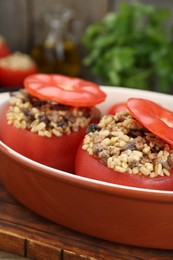 Delicious stuffed tomatoes with minced beef, bulgur and mushrooms in baking dish, closeup