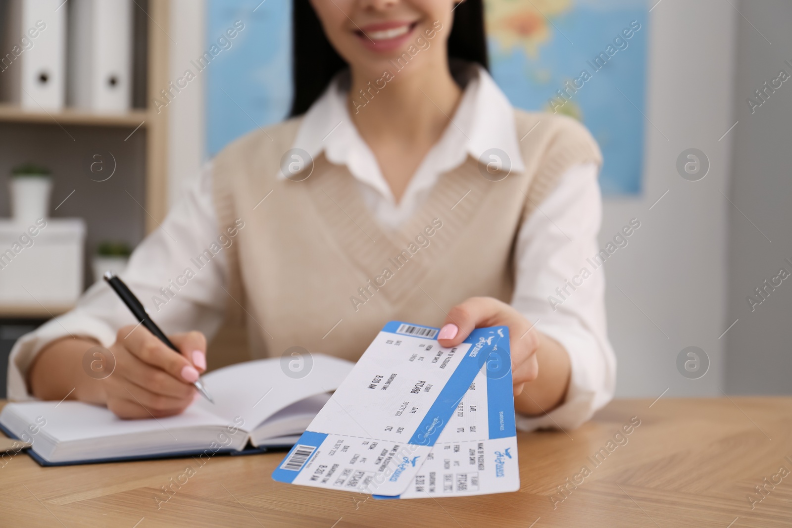 Photo of Travel agent with tickets at table in office, closeup