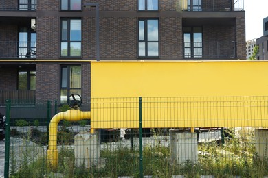 Photo of Big yellow gas distribution cabinet in residential area outdoors