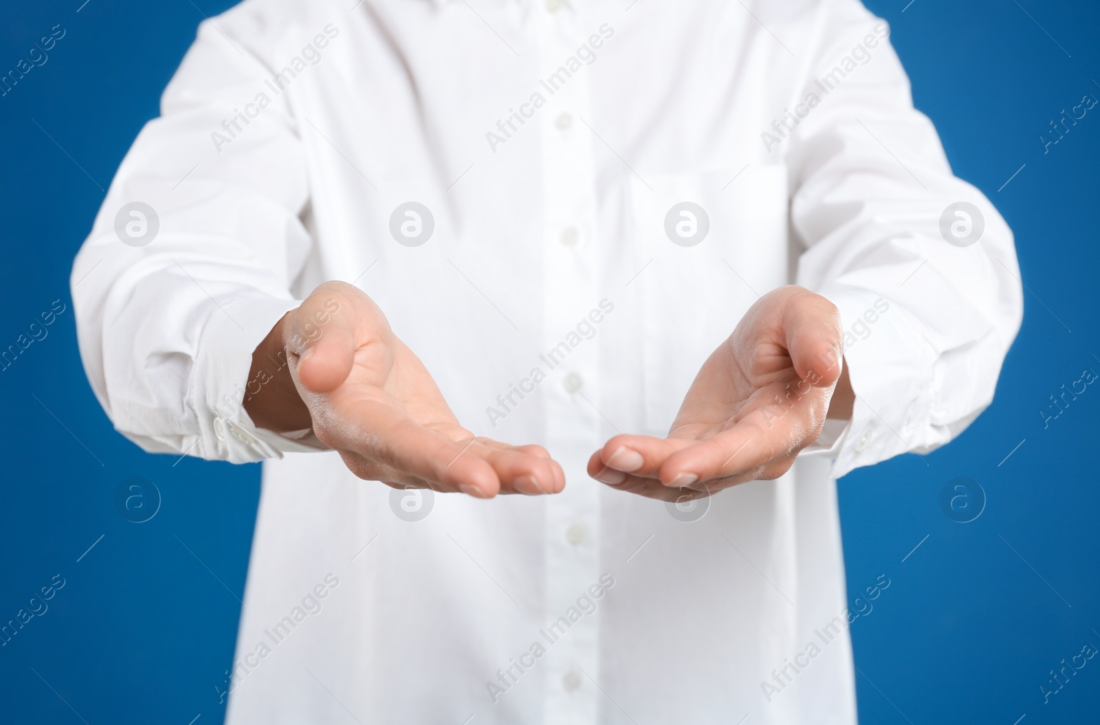 Photo of Woman holding something against blue background, focus on hands