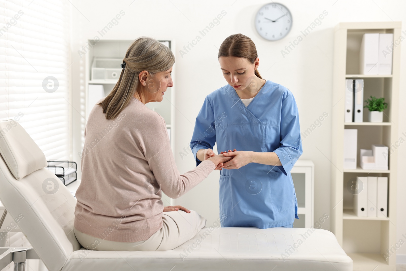 Photo of Arthritis symptoms. Doctor examining patient's wrist in hospital