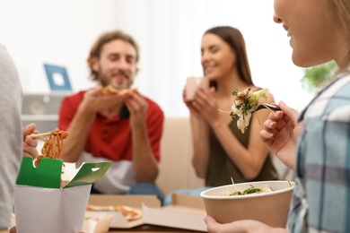 Young people having lunch together at home. Food delivery