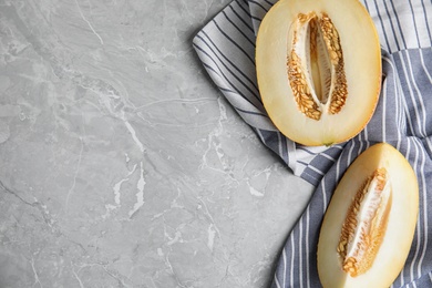 Photo of Tasty cut ripe melon on grey marble table, flat lay. Space for text