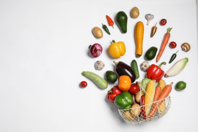 Photo of Fresh vegetables and metal basket on white background, top view