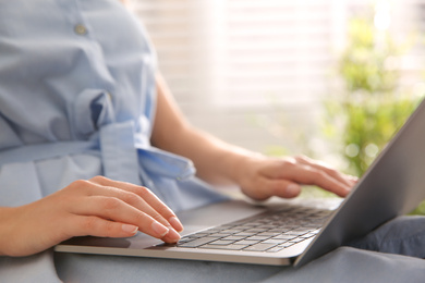 Photo of Woman working with modern laptop indoors, closeup