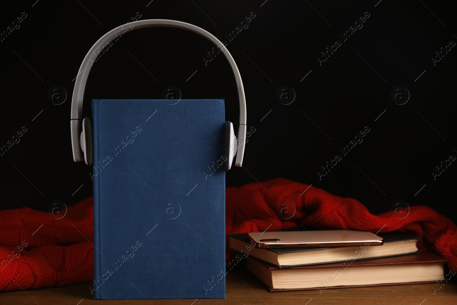 Photo of Books, headphones and mobile phone on wooden table. Space for text