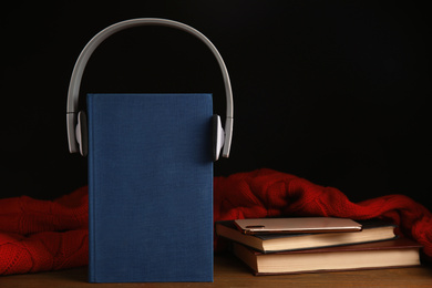 Books, headphones and mobile phone on wooden table. Space for text