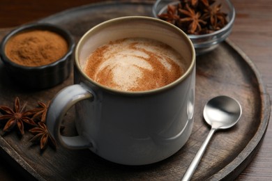 Cup of delicious eggnog with anise on wooden table