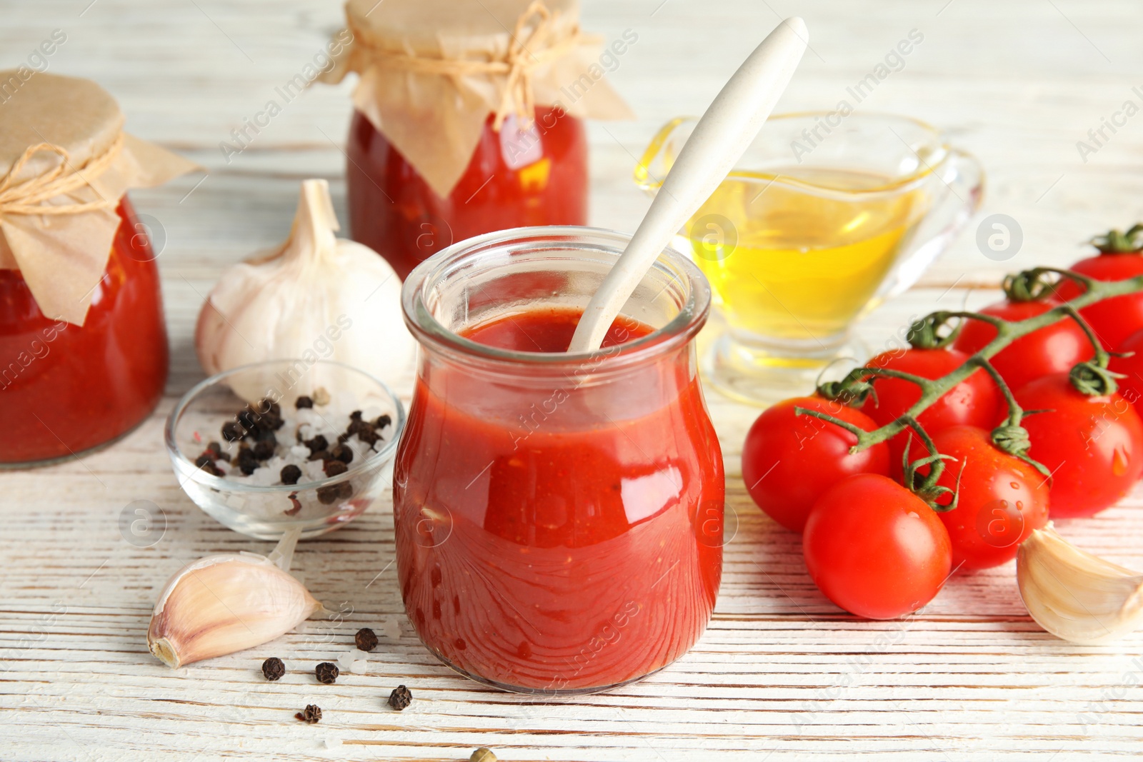 Photo of Composition with tomato sauce, spices and vegetables on wooden table