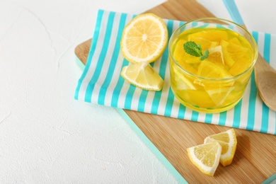 Photo of Glass of lemon jelly served on white table. Space for text