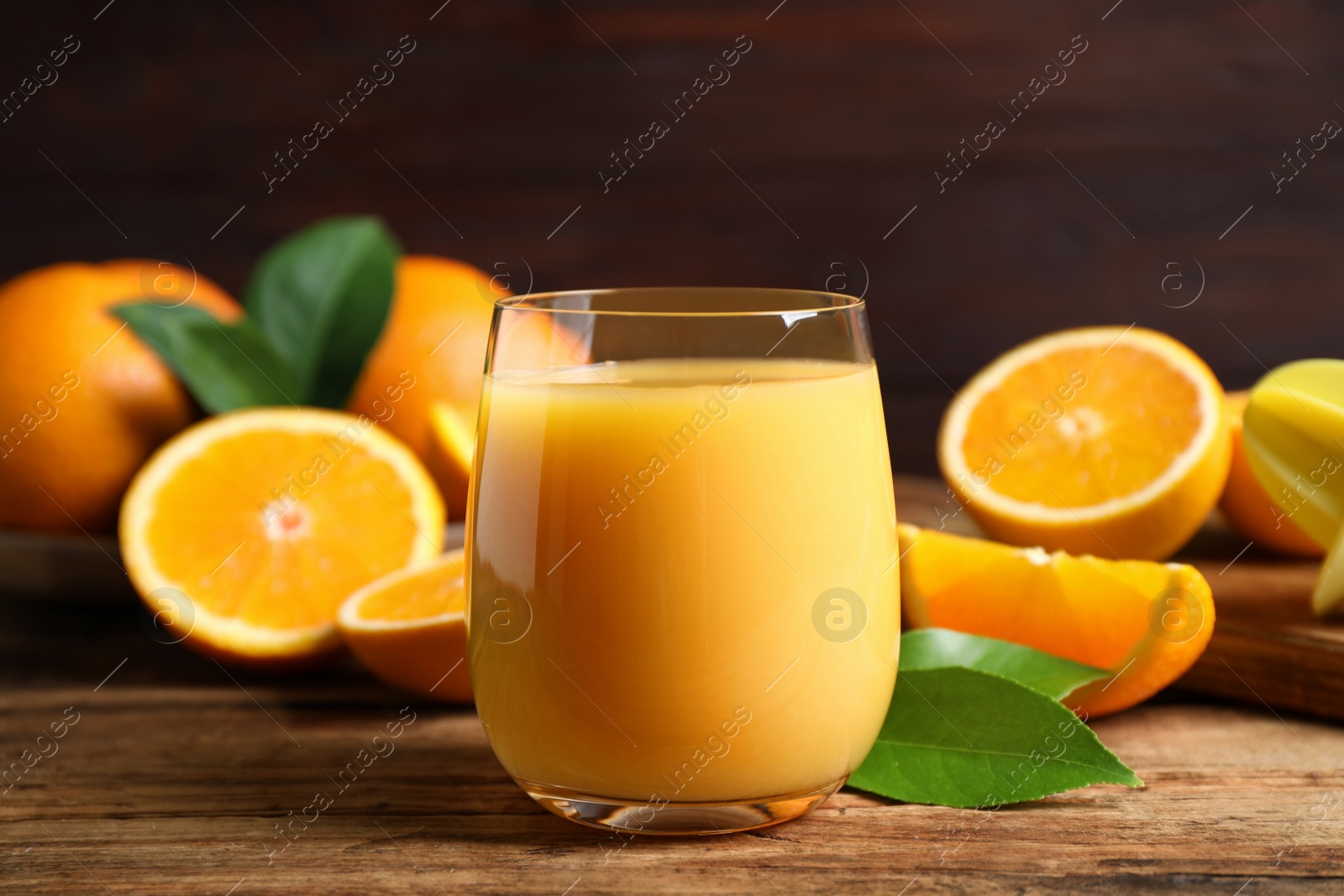 Photo of Glass of orange juice and fresh fruits on wooden table