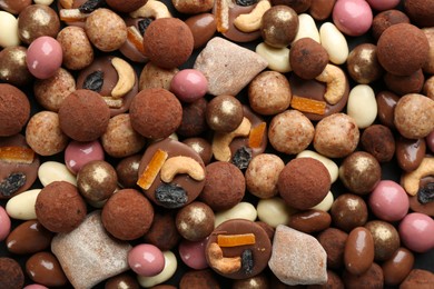 Photo of Different delicious chocolate candies as background, closeup