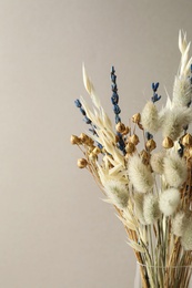 Photo of Dried flowers in vase against light background
