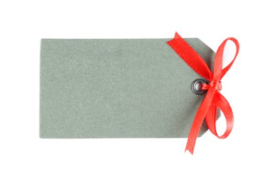 Photo of Blank grey gift tag with red satin ribbon on white background, top view. Space for design