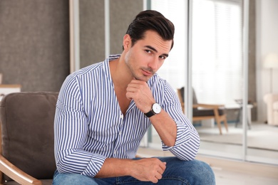 Photo of Portrait on handsome young man sitting in chair indoors