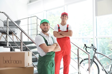 Portrait of male movers in uniform indoors