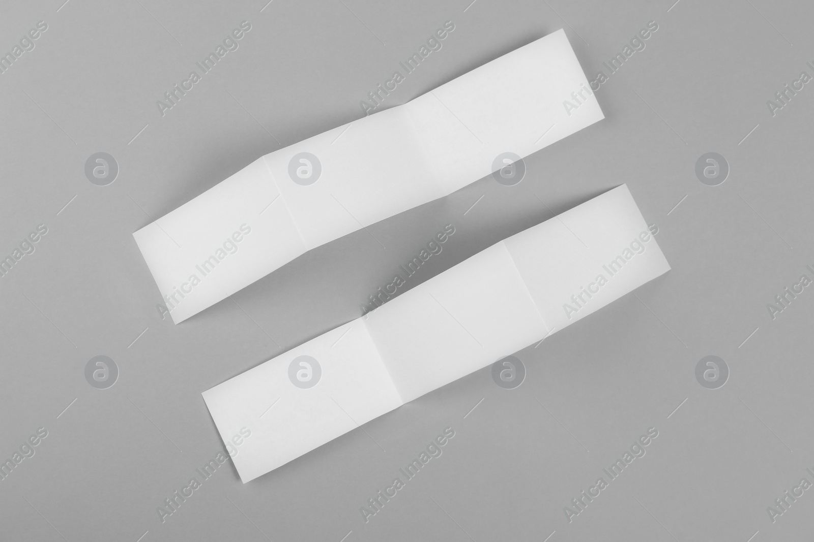 Photo of Blank paper brochures on light grey background, flat lay. Mockup for design