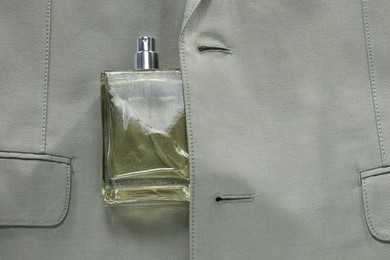 Luxury men's perfume in bottle on grey jacket, top view. Space for text