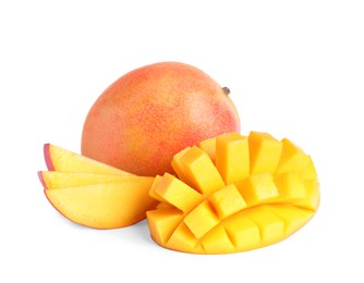 Delicious whole and cut mangoes on white background