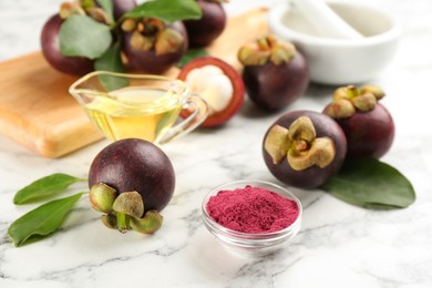 Photo of Purple mangosteen powder and fruits on white marble table