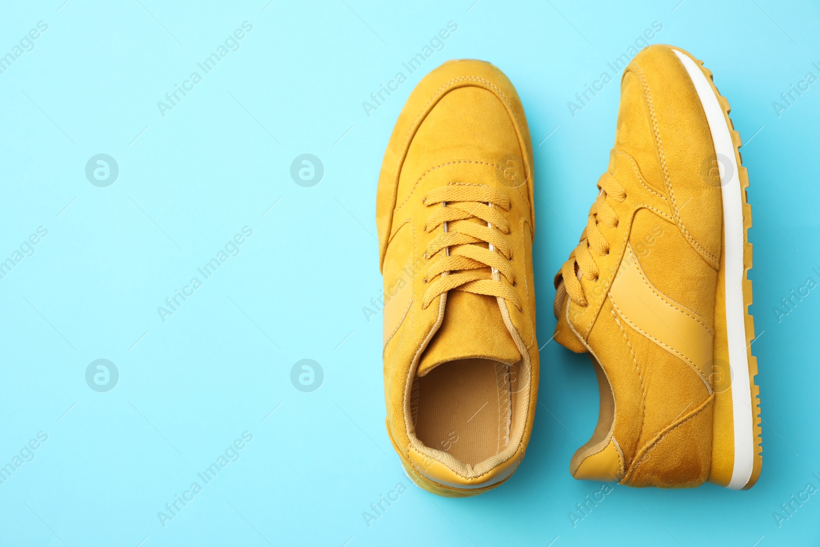 Photo of Pair of stylish shoes on light blue background, top view. Space for text