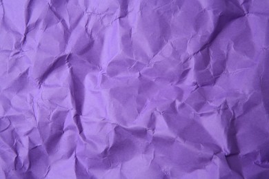 Photo of Sheet of crumpled violet paper as background, top view