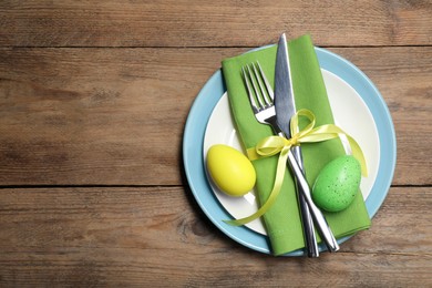Photo of Festive table setting with painted eggs, top view with space for text. Easter celebration