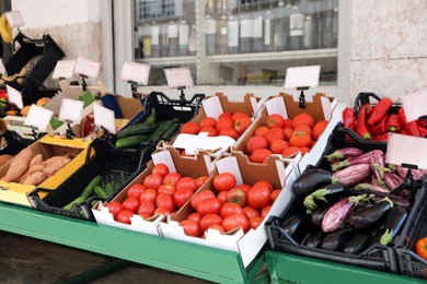 Photo of Tables with variety of fresh ripe vegetables in wholesale market