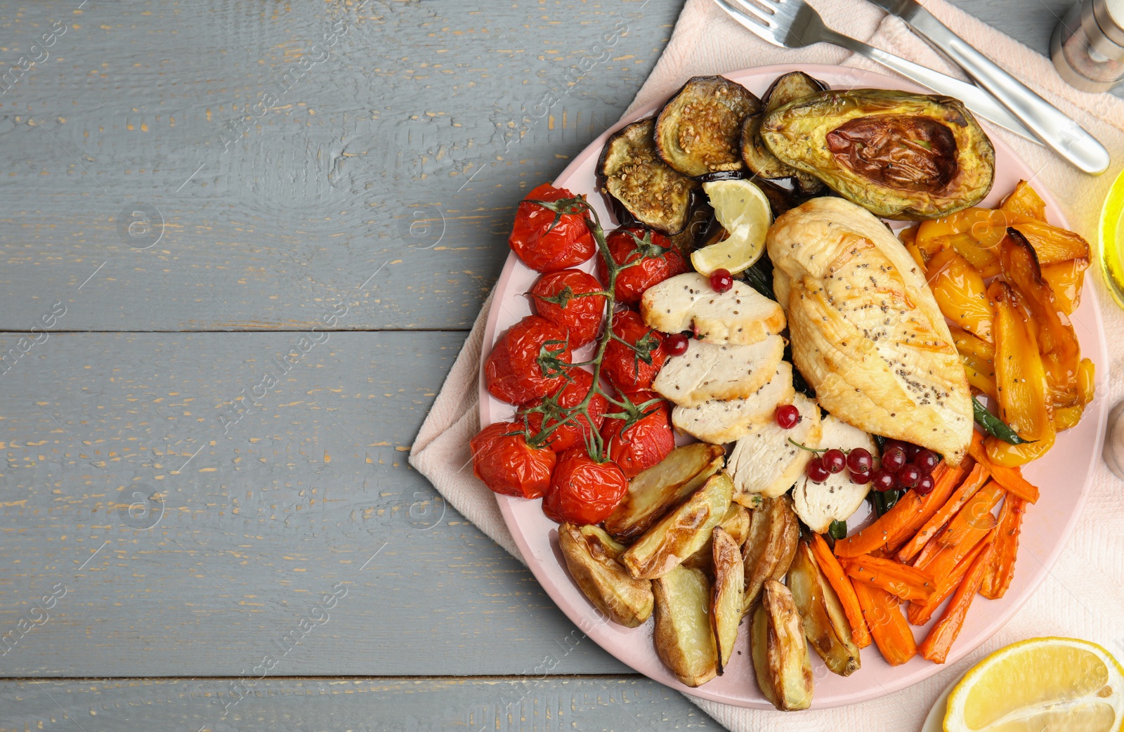 Photo of Tasty cooked chicken fillet and vegetables served on grey wooden table, flat lay with space for text. Healthy meals from air fryer