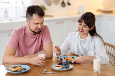 Photo of Happy couple having tasty breakfast at home