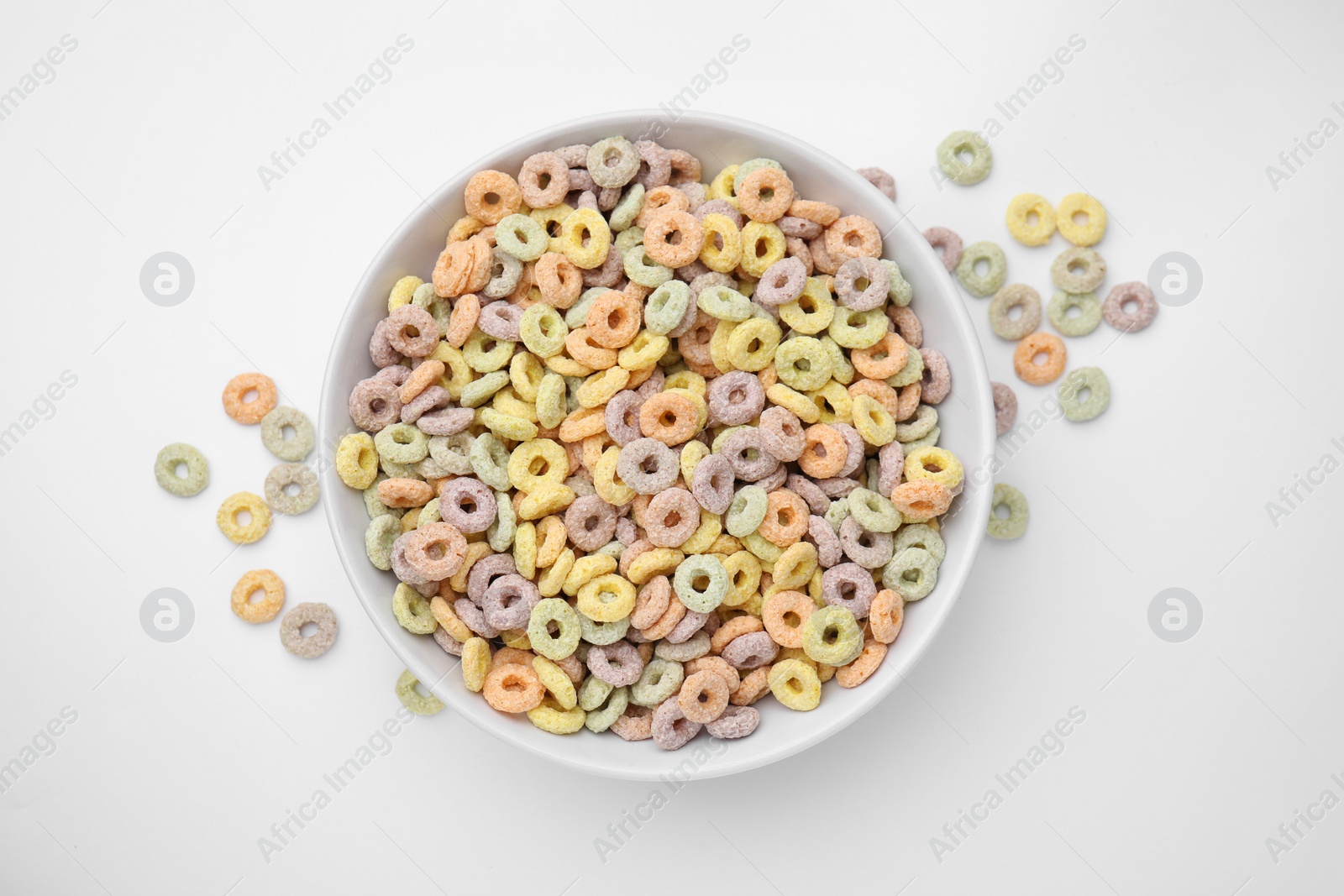 Photo of Tasty cereal rings in bowl on white table, top view