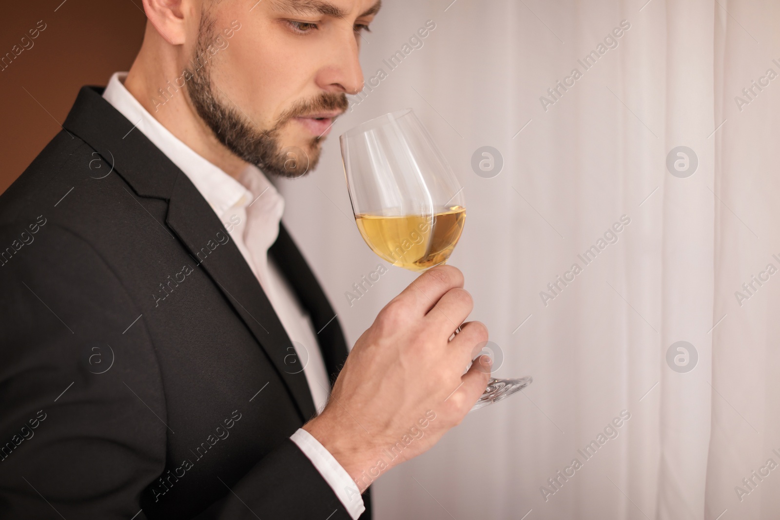 Photo of Young man with glass of wine indoors