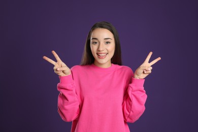 Photo of Woman showing number four with her hands on purple background