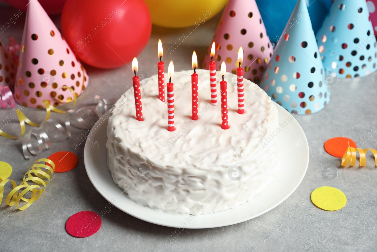 Photo of Delicious birthday cake with burning candles on table