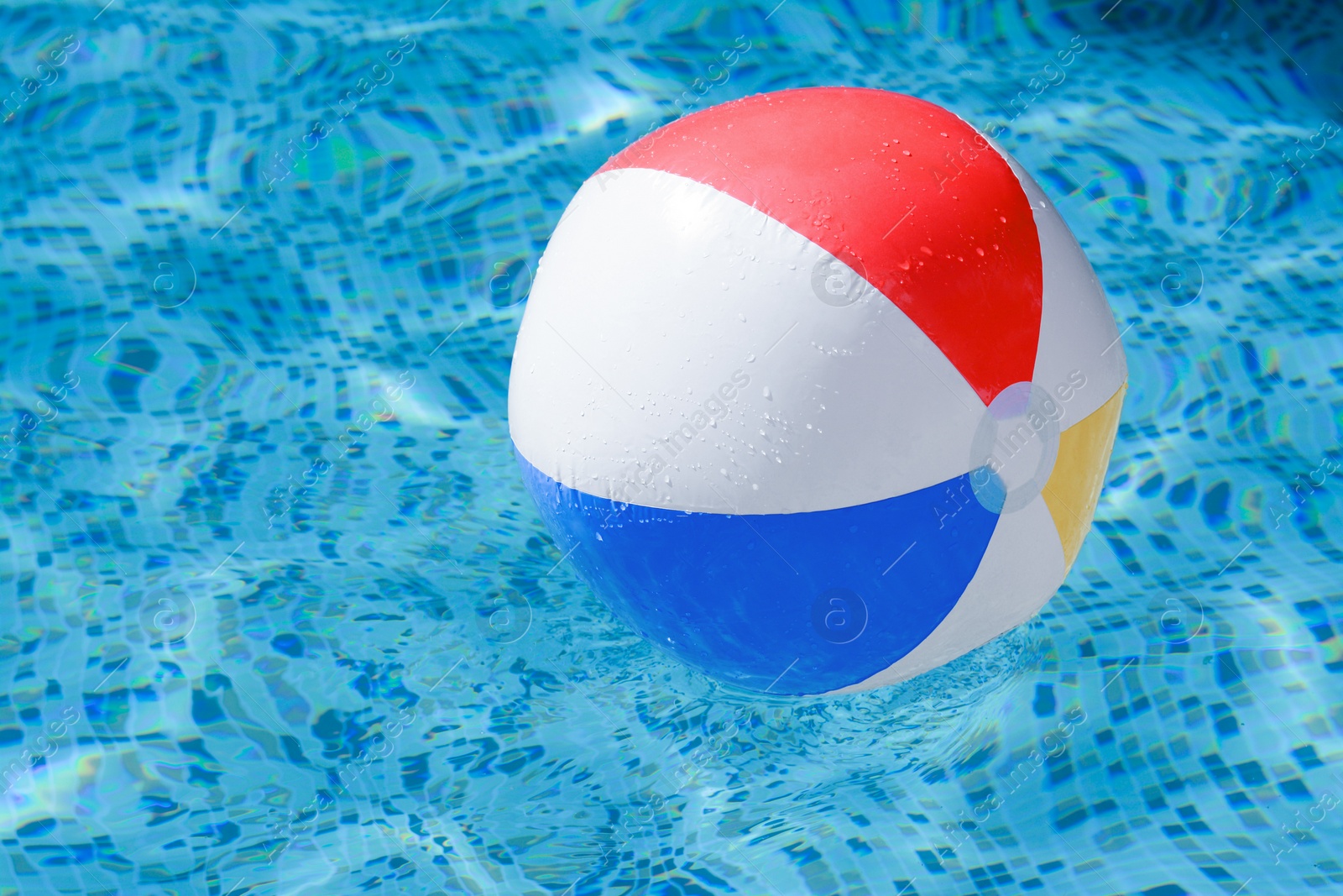 Photo of Inflatable beach ball floating in swimming pool, space for text