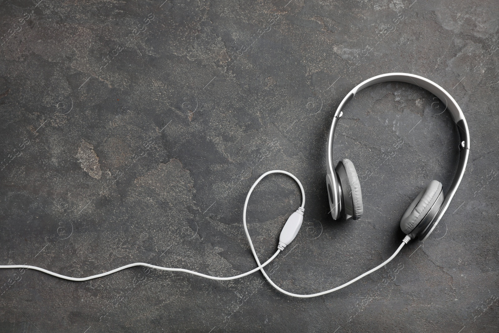 Photo of Stylish modern headphones and space for text on concrete background, top view