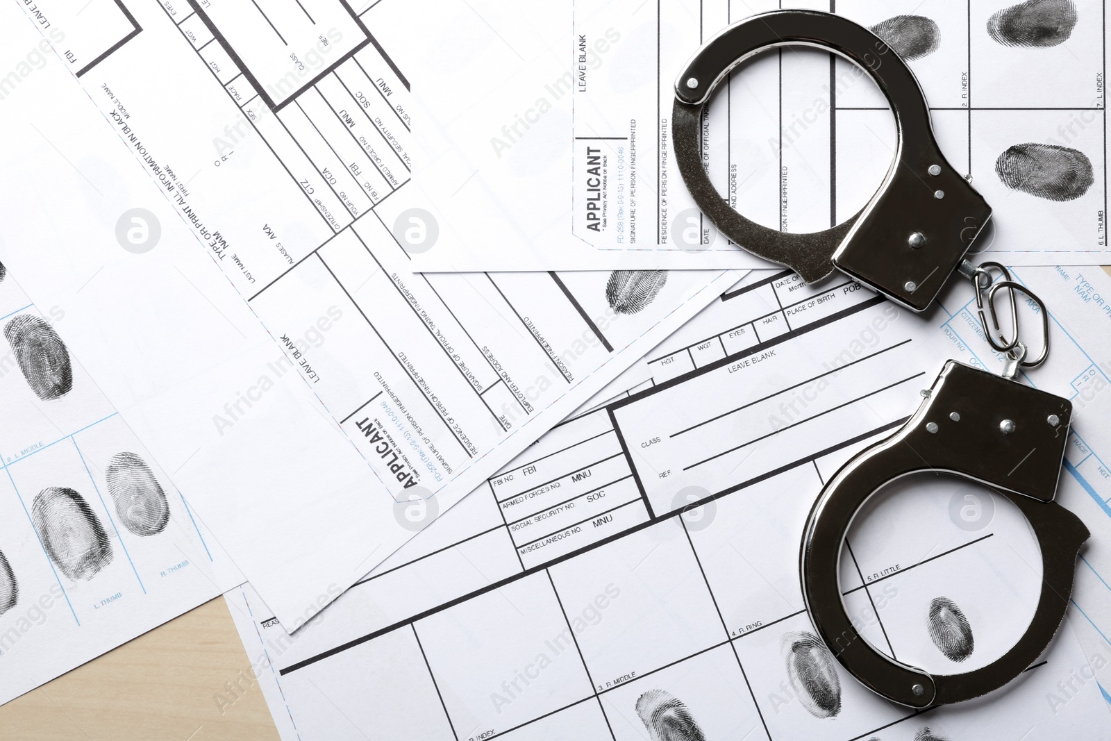 Photo of Handcuffs and fingerprint record sheets, top view. Criminal investigation