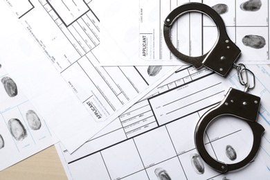 Handcuffs and fingerprint record sheets, top view. Criminal investigation