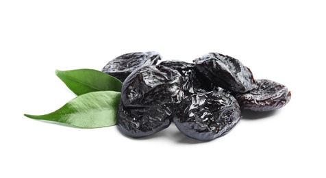 Tasty prunes and leaves on white background. Dried fruit as healthy snack