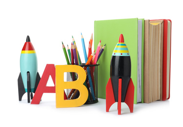 Photo of Bright toy rockets and school supplies on white background
