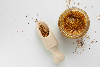 Photo of Fresh whole grain mustard in bowl and dry seeds on white table, flat lay. Space for text