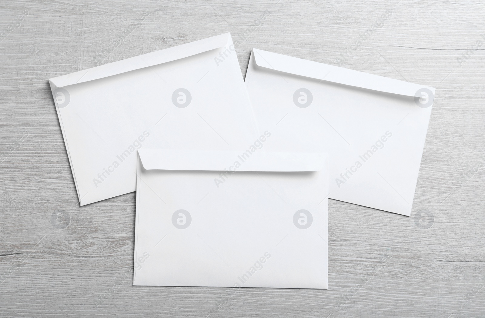 Photo of White paper envelopes on wooden table, flat lay