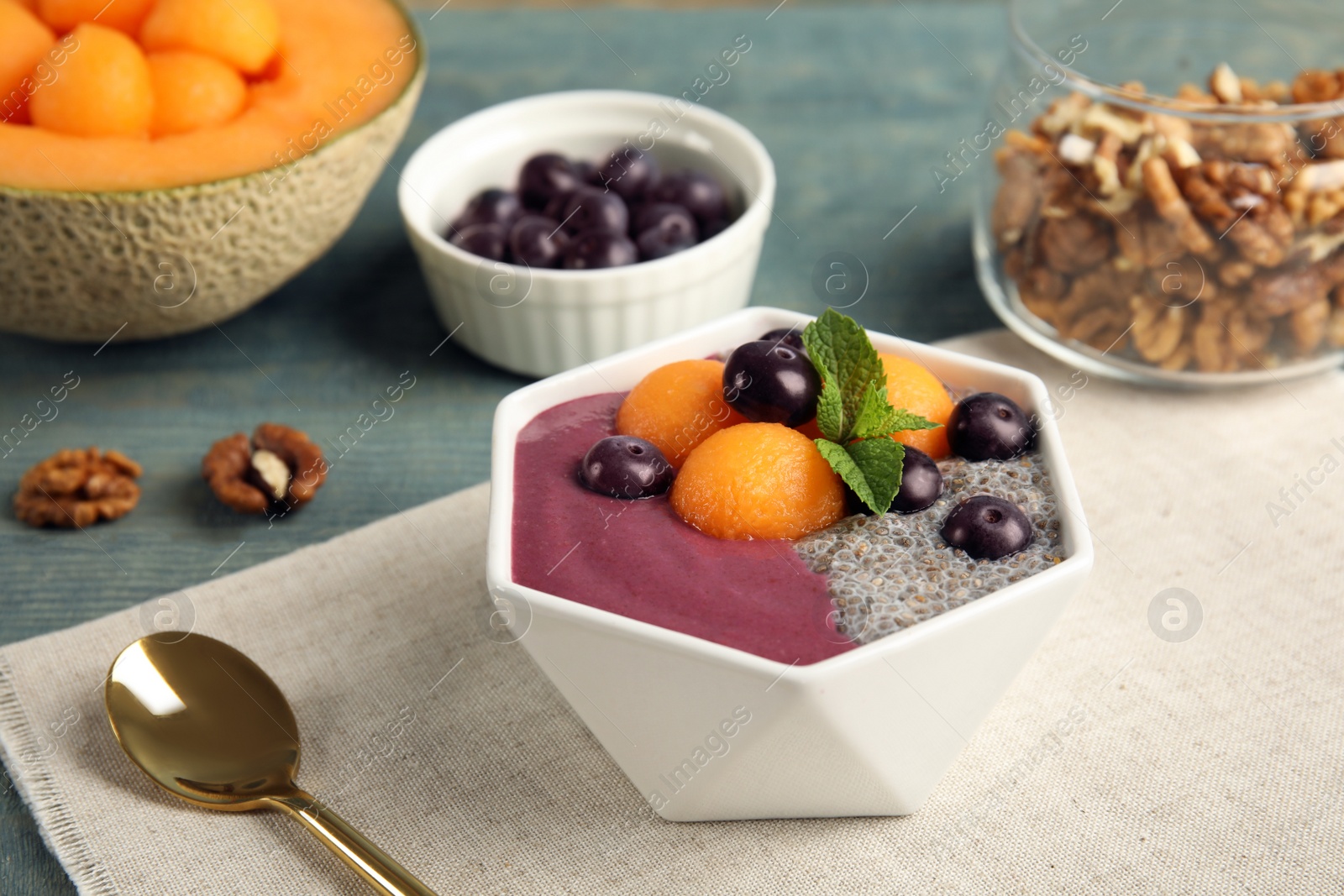 Photo of Bowl with tasty acai smoothie on wooden table