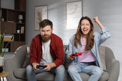 Couple playing video game with controllers at home