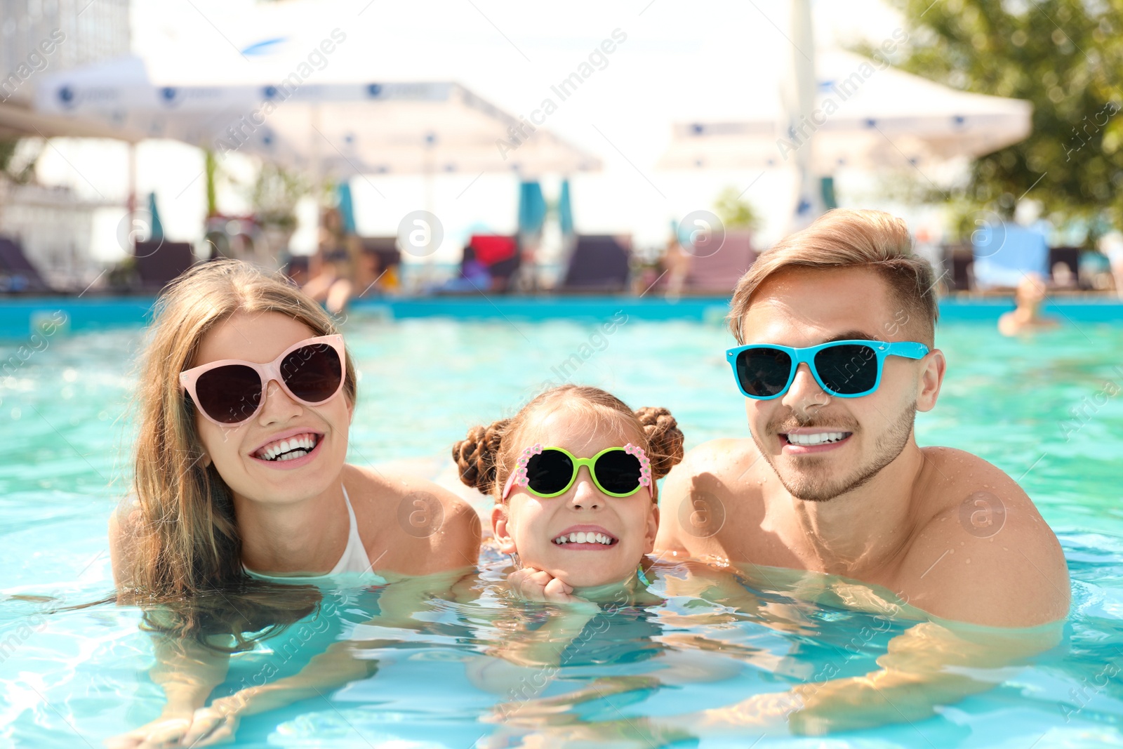 Photo of Happy family in pool on sunny day