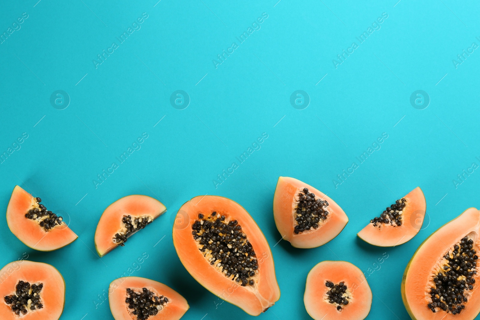 Photo of Fresh ripe papaya fruits on blue background, flat lay. Space for text