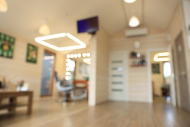 Photo of Blurred view of stylish barbershop interior with professional hairdresser's workplace