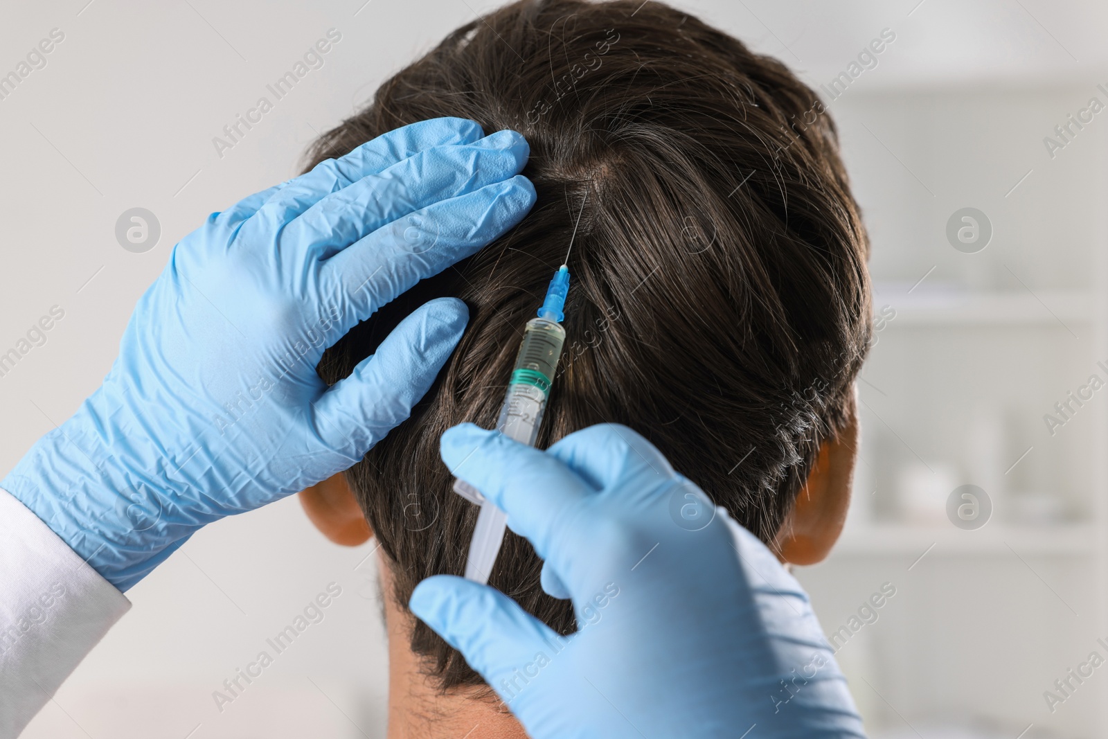 Photo of Trichologist giving injection to patient in clinic, closeup