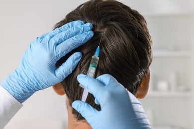 Trichologist giving injection to patient in clinic, closeup